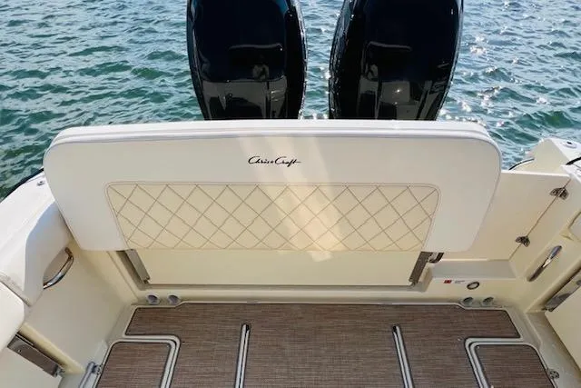 Slide: The Image of 2022 Chris-Craft Calypso 30 boat with dual engines, featuring elegant seating and water backdrop. - 42