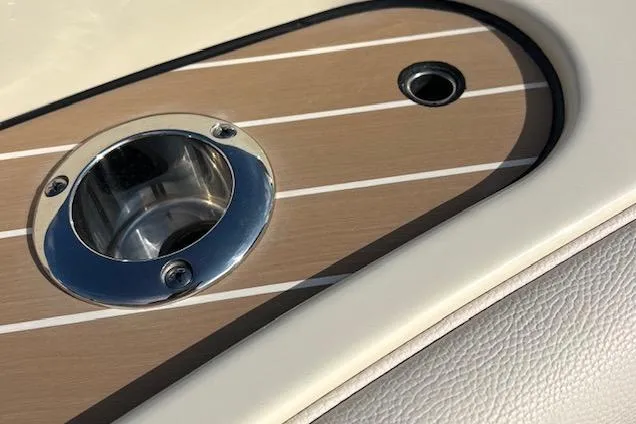 Slide: The Image of Close-up of 2022 Chris-Craft Calypso 30 boat's polished metal cup holder on wood panel. - 5