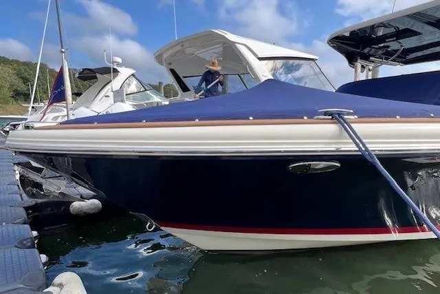 Slide: The Image of 2022 Chris-Craft Calypso 30 boat docked with blue cover and white trim. - 6