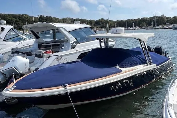Slide: The Image of 2022 Chris-Craft Calypso 30 boat docked, covered with a blue tarp, in a marina setting. - 7