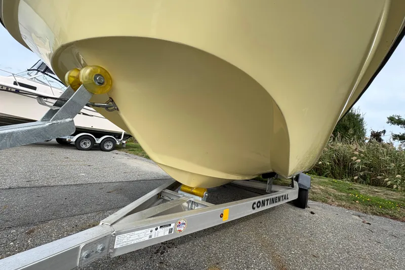 Slide: The Image of 2024 Wolfeboro 15 Classic boat on Continental trailer, parked on asphalt. - 2