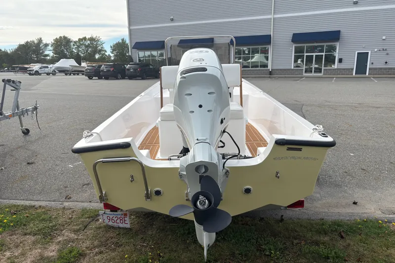 Slide: The Image of 2024 Wolfeboro 15 Classic boat with outboard motor, parked outdoors near a building. - 4