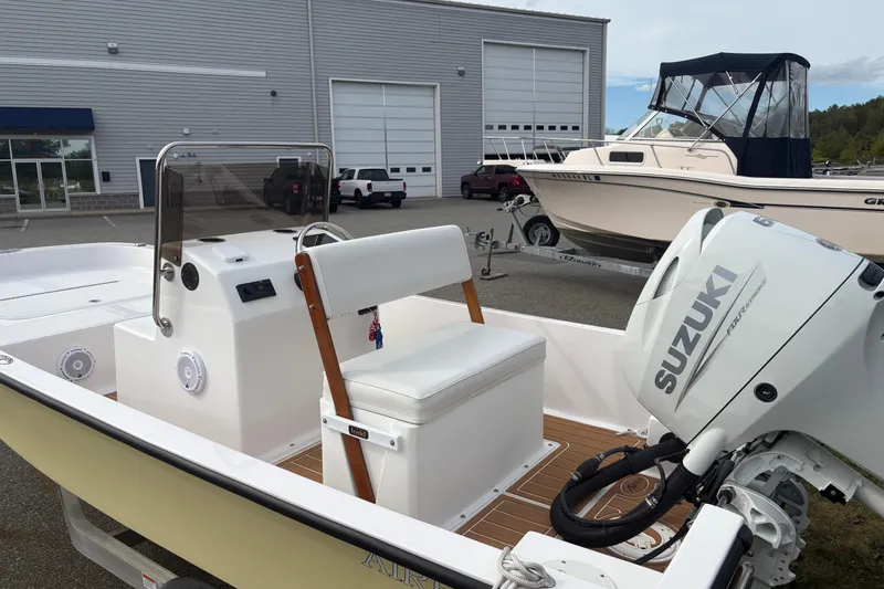 Slide: The Image of 2024 Wolfeboro 15 Classic boat with Suzuki outboard motor in a marina setting. - 6