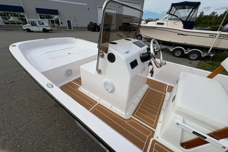 Slide: The Image of 2024 Wolfeboro 15 Classic boat with sleek console and modern design in a marina setting. - 9