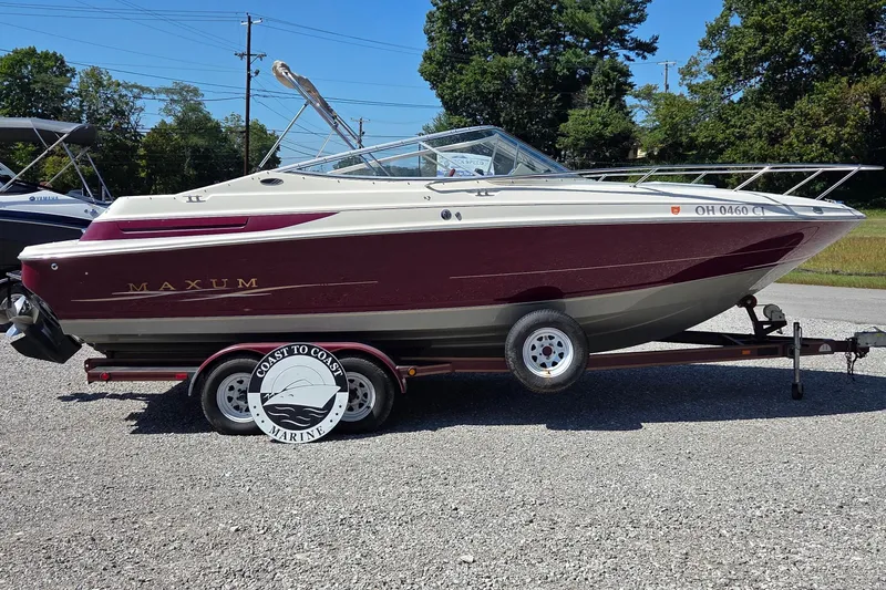 Slide: The Image of 1998 Maxum 2300 SC boat on trailer, maroon and white, parked outdoors. - 0