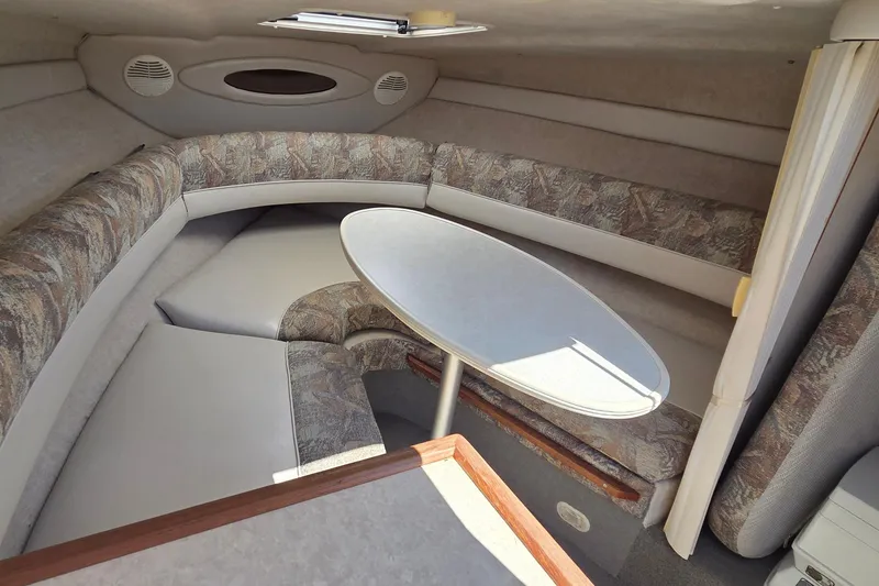 Slide: The Image of 1998 Maxum 2300 SC cabin interior with cushioned seating and oval table. - 10