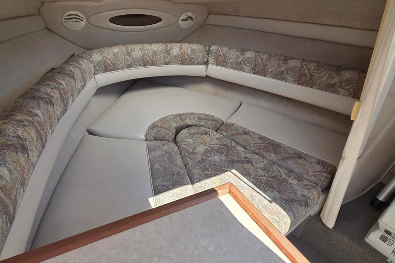 Slide: The Image of 1998 Maxum 2300 SC cabin interior with cushioned seating and patterned upholstery. - 11