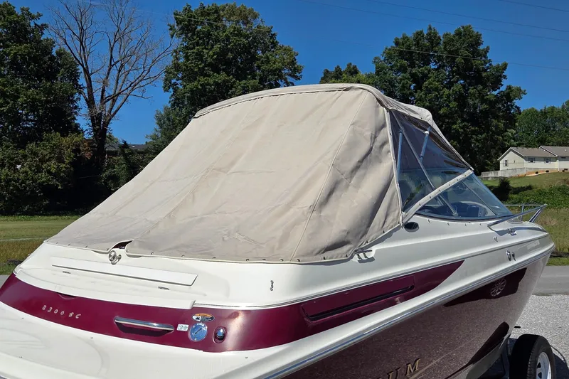 Slide: The Image of 1998 Maxum 2300 SC boat with beige cover, parked outdoors on a sunny day. - 14