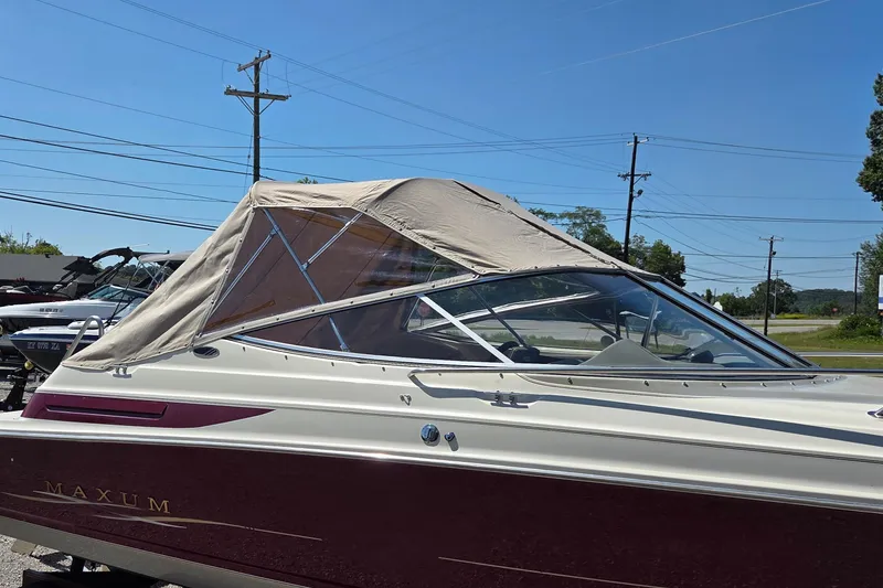 Slide: The Image of 1998 Maxum 2300 SC boat with canopy, parked outdoors on a sunny day. - 15