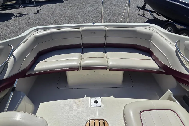 Slide: The Image of 1998 Maxum 2300 SC boat interior with beige and maroon seating, spacious layout. - 8