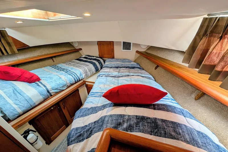 Slide: The Image of Interior of 1978 Tollycraft 54 Custom Cockpit Motor Yacht with twin beds and red pillows. - 32