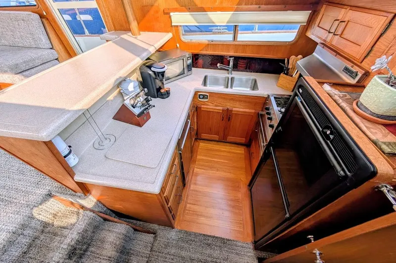 Slide: The Image of 1978 Tollycraft 54 Custom Cockpit Motor Yacht kitchen with wood cabinetry and modern appliances. - 22