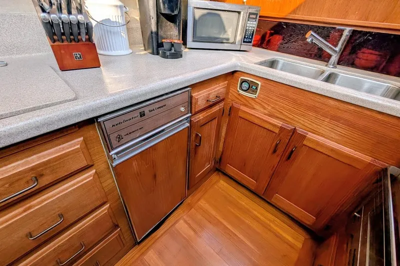 Slide: The Image of 1978 Tollycraft 54 Custom Yacht kitchen with wood cabinets, microwave, and dual sink. - 24