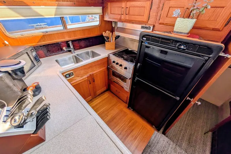 Slide: The Image of 1978 Tollycraft 54 Custom Cockpit Motor Yacht kitchen with wood cabinetry and modern appliances. - 25