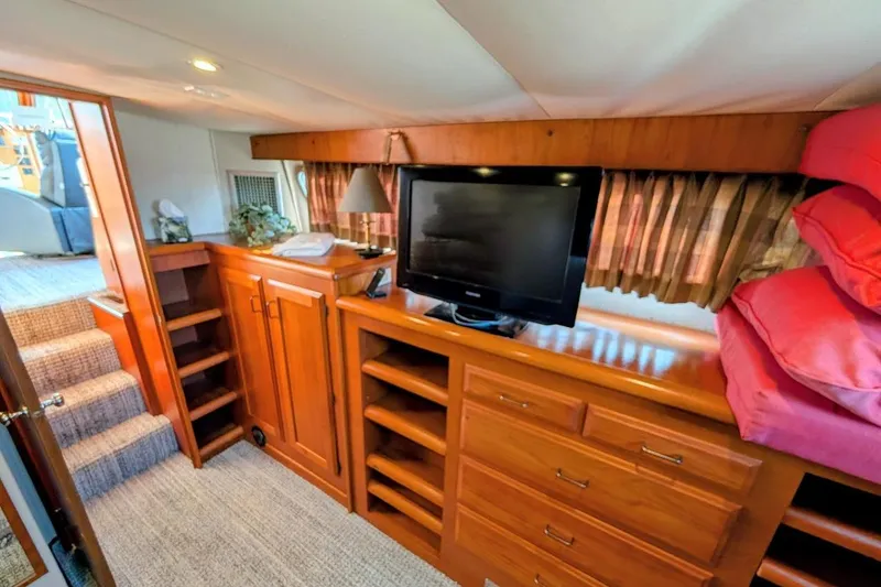 Slide: The Image of 1978 Tollycraft 54 Custom Cockpit Motor Yacht interior with TV, wooden cabinetry, and stairs. - 39