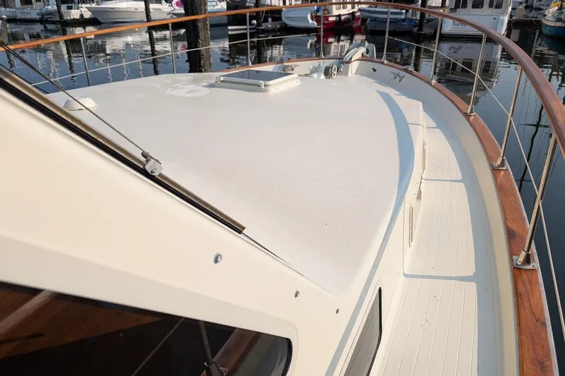 Slide: The Image of 1978 Tollycraft 54 Custom Cockpit Motor Yacht deck with wooden railings in marina. - 5
