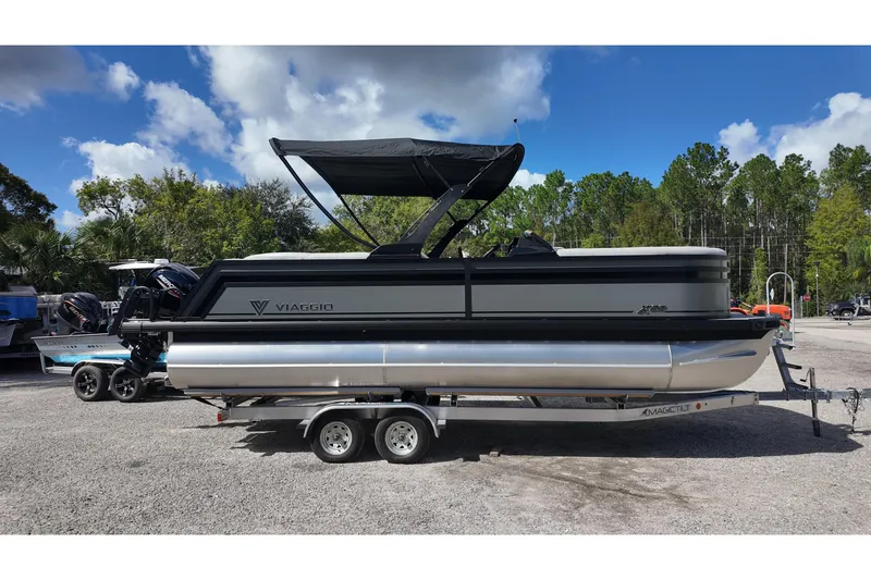 Slide: The Image of 2026 Viaggio Lago X22U pontoon boat on trailer, parked outdoors under blue sky. - 4