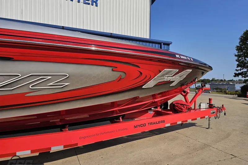 Slide: The Image of 2011 Sunsation F-4 speedboat on a red Myco trailer, parked outdoors. - 13