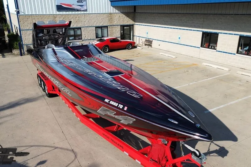 Slide: The Image of 2011 Sunsation F-4 speedboat on red trailer, parked outside a building. - 16