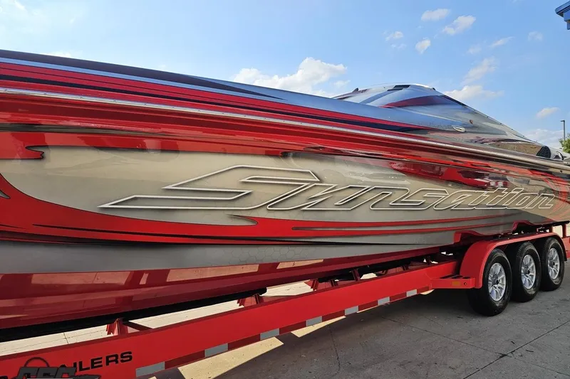 Slide: The Image of 2011 Sunsation F-4 powerboat with sleek red and silver design on a trailer. - 21