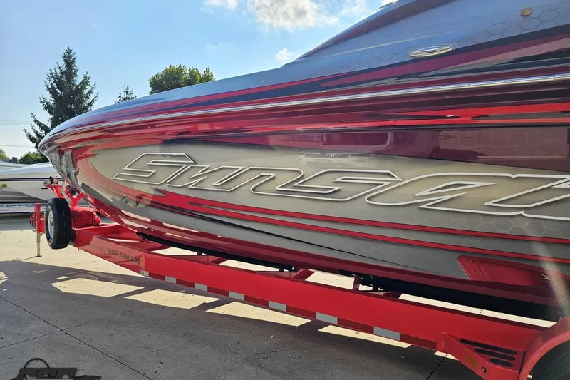 Slide: The Image of 2011 Sunsation F-4 speedboat on red trailer, sleek design, sunny day. - 27
