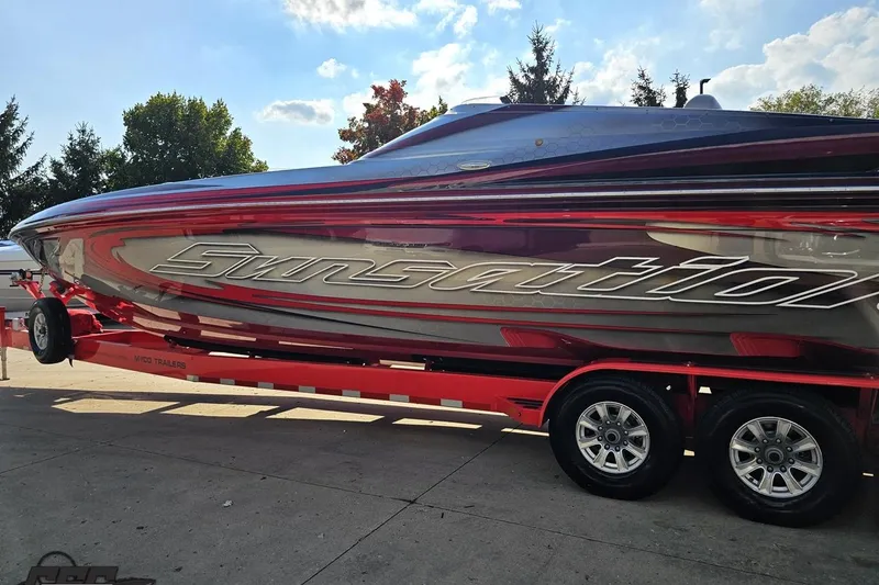 Slide: The Image of 2011 Sunsation F-4 powerboat on a red trailer, parked outdoors. - 28