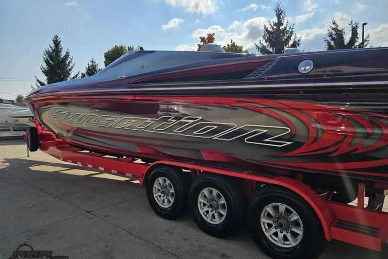 Slide: The Image of 2011 Sunsation F-4 powerboat on trailer, sleek design with vibrant graphics. - 29