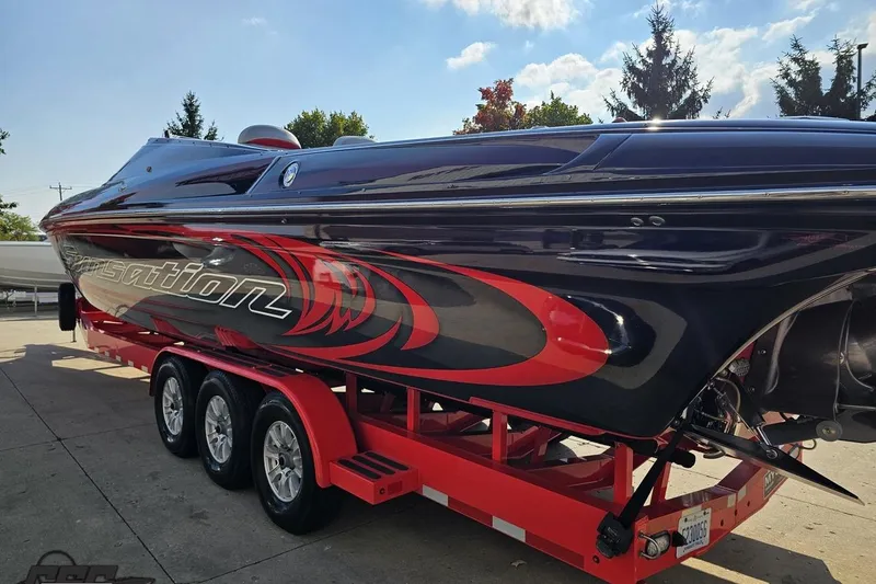 Slide: The Image of 2011 Sunsation F-4 powerboat on a red trailer, featuring sleek black and red design. - 30