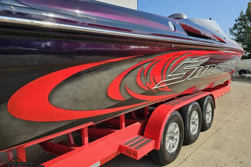 Slide: The Image of 2011 Sunsation F-4 speedboat with vibrant red and black design on a matching trailer. - 38
