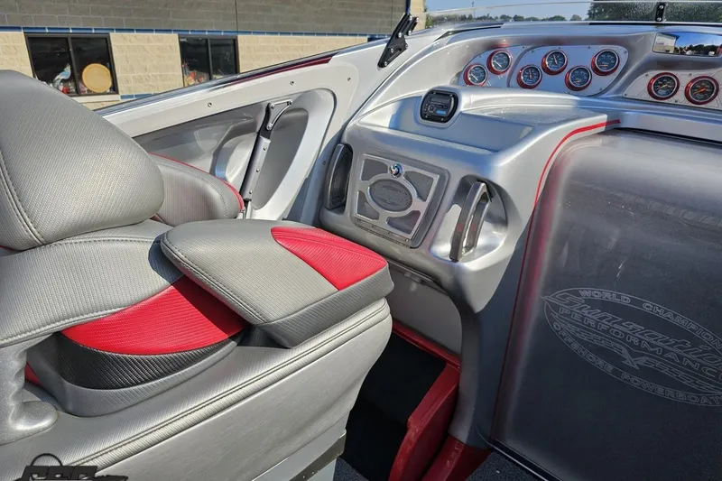 Slide: The Image of 2011 Sunsation F-4 boat interior with red and gray seating, dashboard gauges. - 56