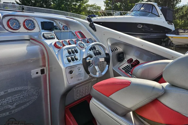 Slide: The Image of 2011 Sunsation F-4 boat cockpit with modern controls and red-accented seating. - 64