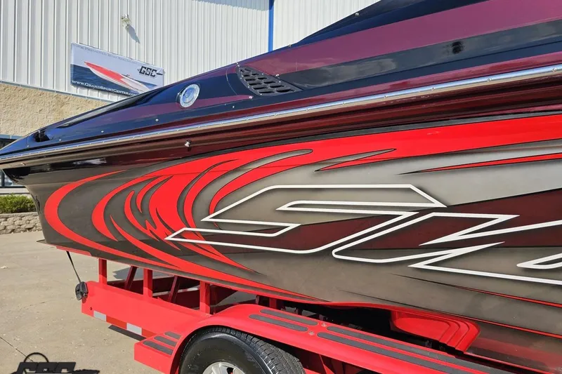 Slide: The Image of 2011 Sunsation F-4 boat with vibrant red and black graphics on a trailer. - 7