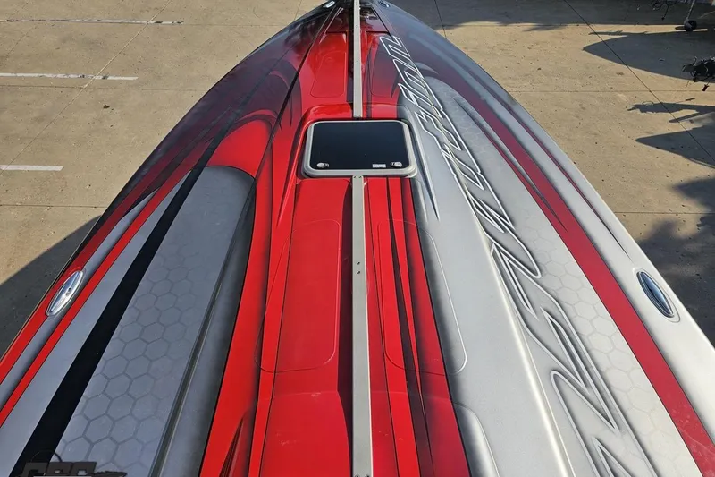 Slide: The Image of 2011 Sunsation F-4 boat with sleek red and gray design on a concrete surface. - 71