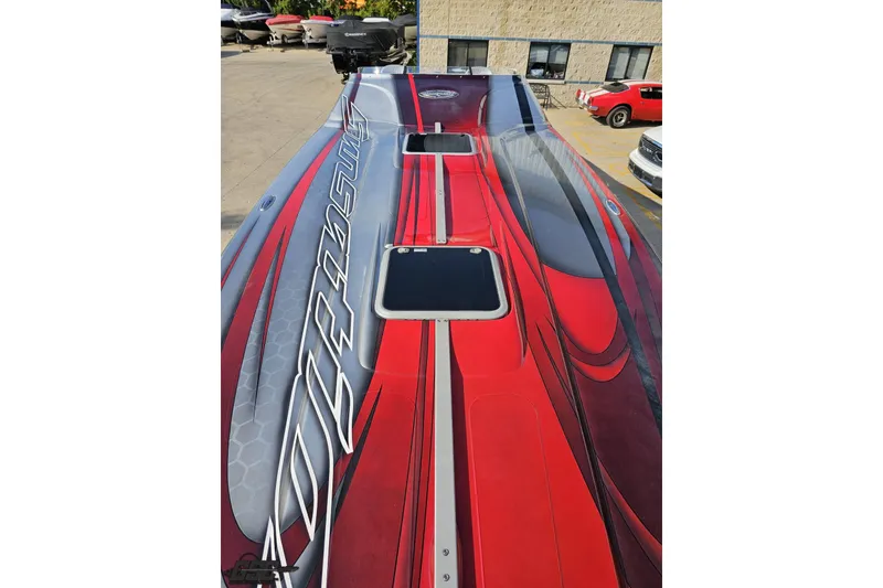 Slide: The Image of 2011 Sunsation F-4 powerboat with sleek red and gray design, parked outdoors. - 73