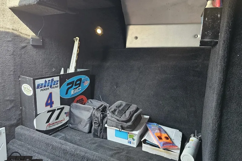 Slide: The Image of Interior of 2011 Sunsation F-4 boat with storage items and racing decals. - 84