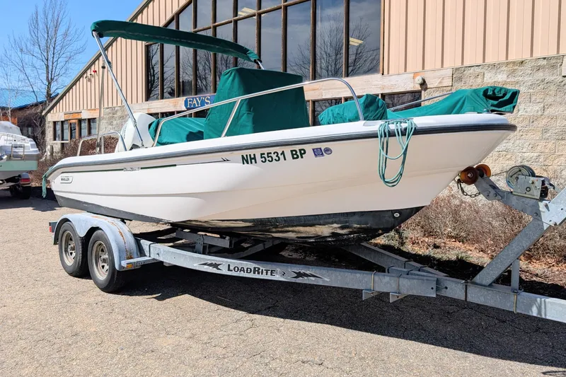 The Image of 1999 Boston Whaler 180 Dauntless boat on trailer, parked outdoors. - 0