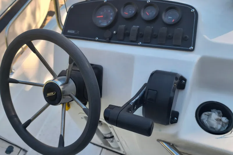 Slide: The Image of Steering console of a 2002 Boston Whaler 180 Dauntless boat with gauges and controls. - 10