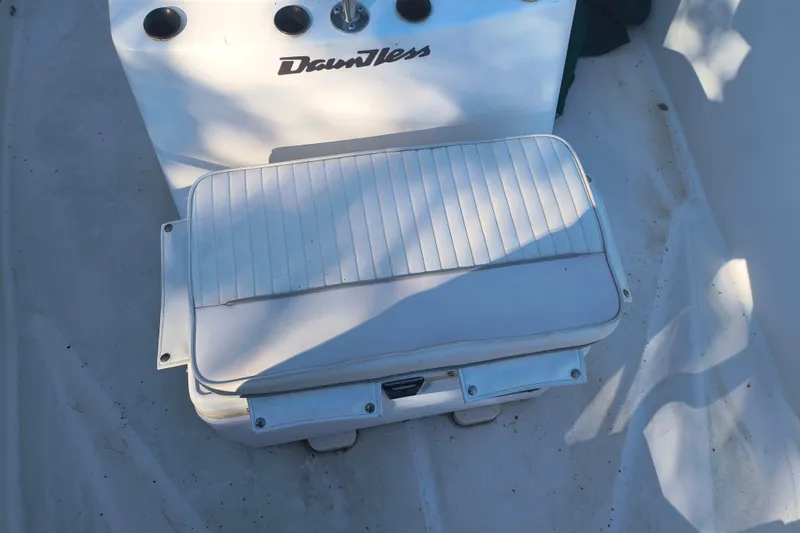 Slide: The Image of 2002 Boston Whaler 180 Dauntless boat interior with white cushioned seating. - 19