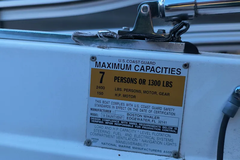 Slide: The Image of Capacity label on 2002 Boston Whaler 180 Dauntless, showing limits for persons and weight. - 23