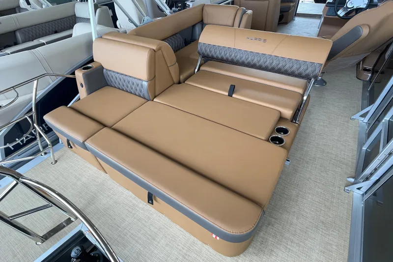 Slide: The Image of Luxurious seating on 2026 Harris Cruiser 210 pontoon boat, featuring tan upholstery and cup holders. - 10