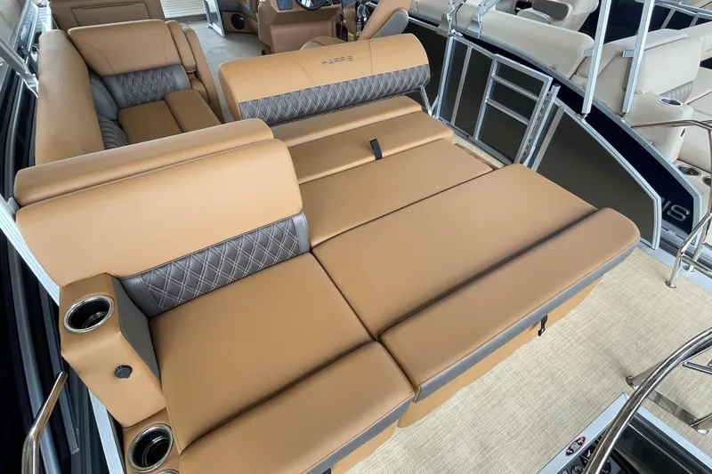Slide: The Image of 2026 Harris Cruiser 210 boat interior with tan and gray seating, featuring cup holders. - 11