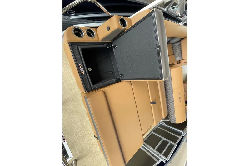Slide: The Image of 2026 Harris Cruiser 210 boat interior with tan seating and open storage compartment. - 12