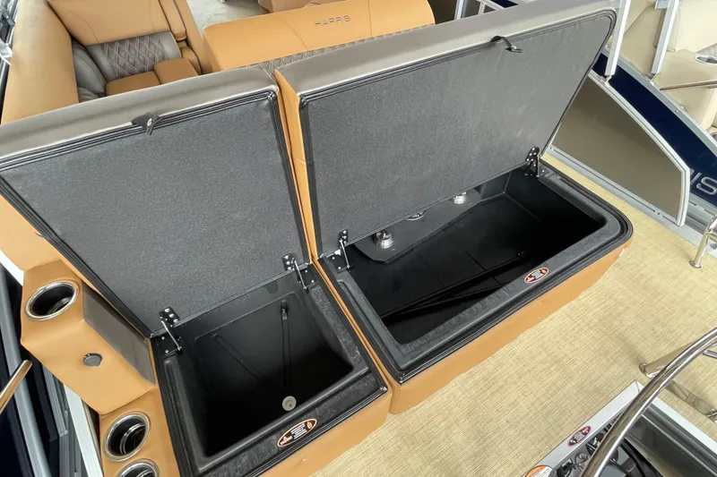 Slide: The Image of 2026 Harris Cruiser 210 boat with open storage compartments and tan seating. - 13