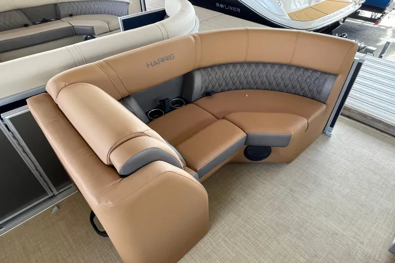 Slide: The Image of Luxurious seating on 2026 Harris Cruiser 210 pontoon boat, featuring tan upholstery and cup holders. - 4