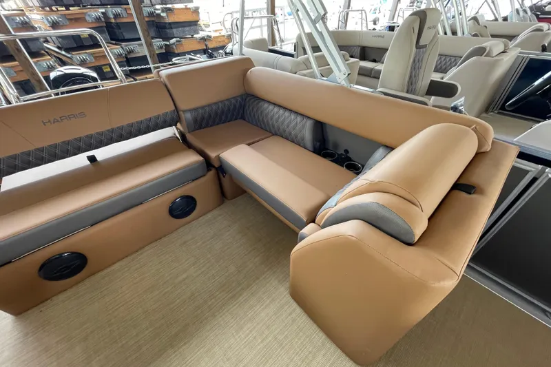 Slide: The Image of Luxurious seating on 2026 Harris Cruiser 210 pontoon boat, featuring tan upholstery and cup holders. - 7