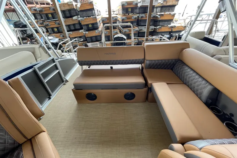 Slide: The Image of Luxurious interior of 2026 Harris Cruiser 210 pontoon boat with tan seating and storage. - 8