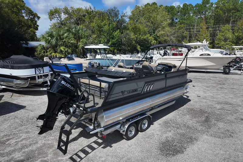Slide: The Image of 2026 Viaggio Diamante D22S pontoon boat with Suzuki engine on trailer, surrounded by other boats. - 2