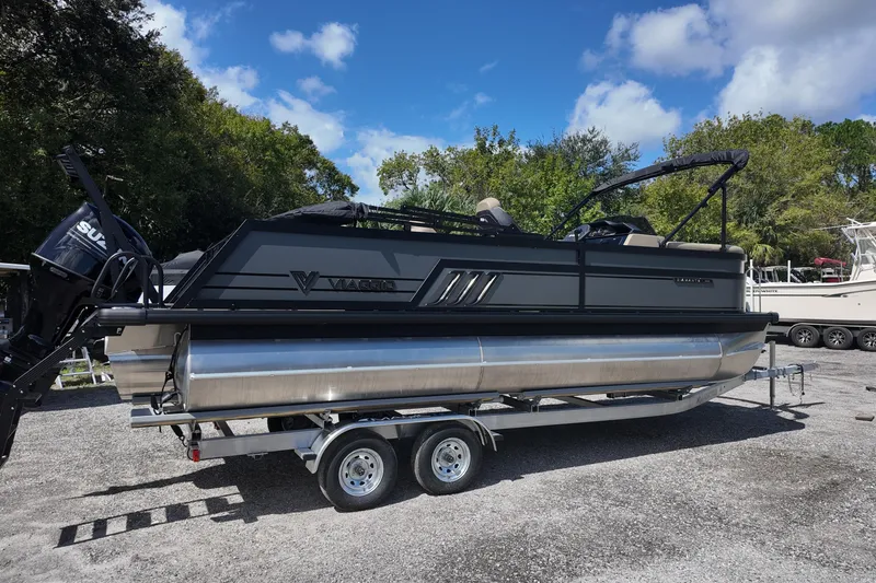 Slide: The Image of 2026 Viaggio Diamante D22S pontoon boat on trailer, parked outdoors under blue sky. - 3