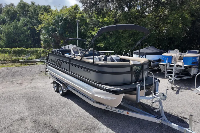 Slide: The Image of 2026 Viaggio Diamante D22S pontoon boat on trailer, surrounded by trees and other boats. - 4