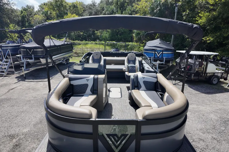 Slide: The Image of 2026 Viaggio Diamante D22S pontoon boat with luxurious seating and canopy, parked outdoors. - 7